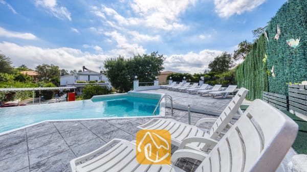 Vakantievilla's Costa Brava Spanje - Villa Geolouk - Privézwembad met meerdere witte kunststof ligstoelen op een betegeld terras bij Villa Geolouk in Spanje.
