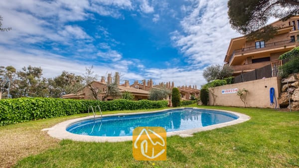 Vakantievilla's Costa Brava Spanje - Casa Costa - Gebogen buitenzwembad gelegen in een grasveld omgeven door groene hagen en bakstenen herenhuizen bij Casa Costa.