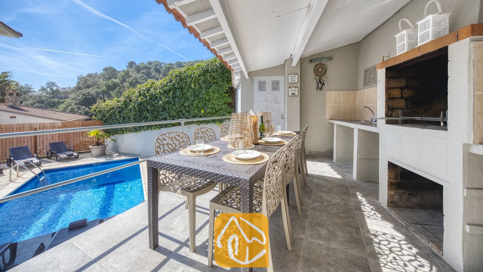 Vakantievilla's Costa Brava Spanje - Villa Rosa - Overdekt terras bij Villa Rosa met een eettafel buiten, een ingebouwde barbecue en uitzicht op het zwembad.