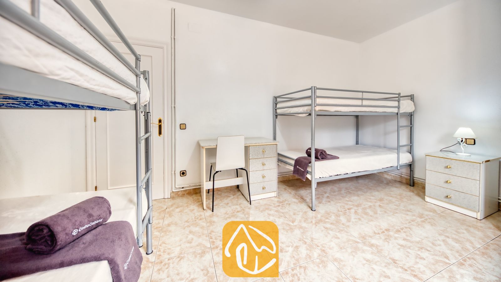 Vakantievilla's Costa Brava Spanje - Villa Sarai - Slaapkamer met twee metalen stapelbedden, een wit bureau en een tegelvloer.