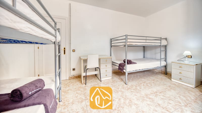 Villas de vacances Costa Brava Espagne - Villa Sarai - Chambre avec deux lits superposés en métal, un bureau blanc et un sol carrelé.