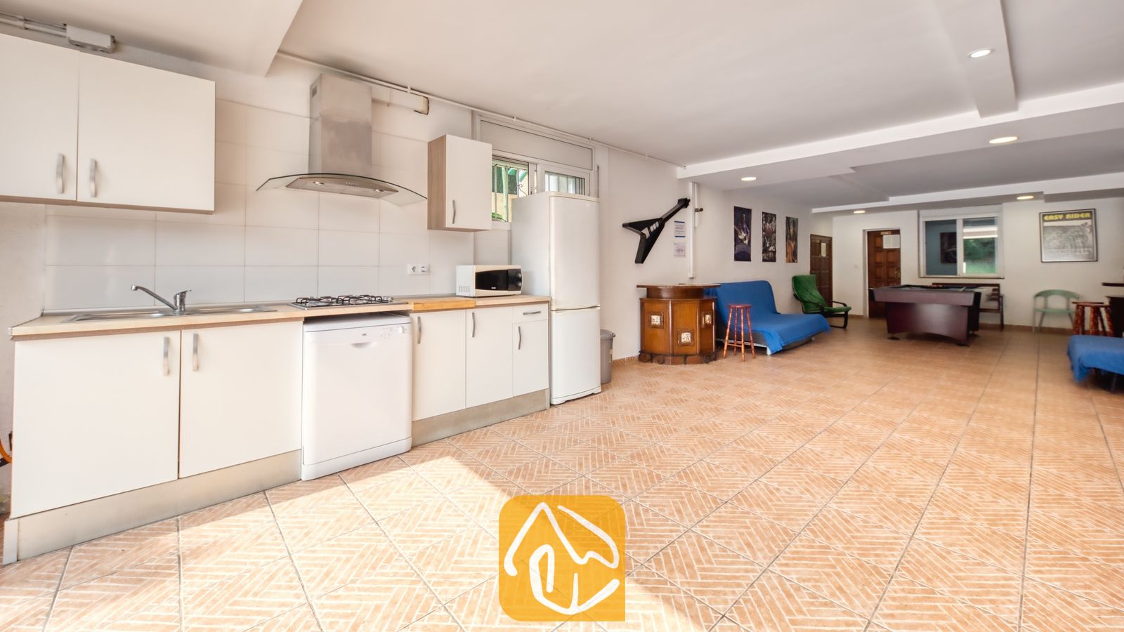 Vakantievilla's Costa Brava Spanje - Villa Ashley - De keuken en recreatieruimte van Villa Ashley zijn voorzien van witte kasten, een pooltafel en karakteristieke terracotta vloertegels.