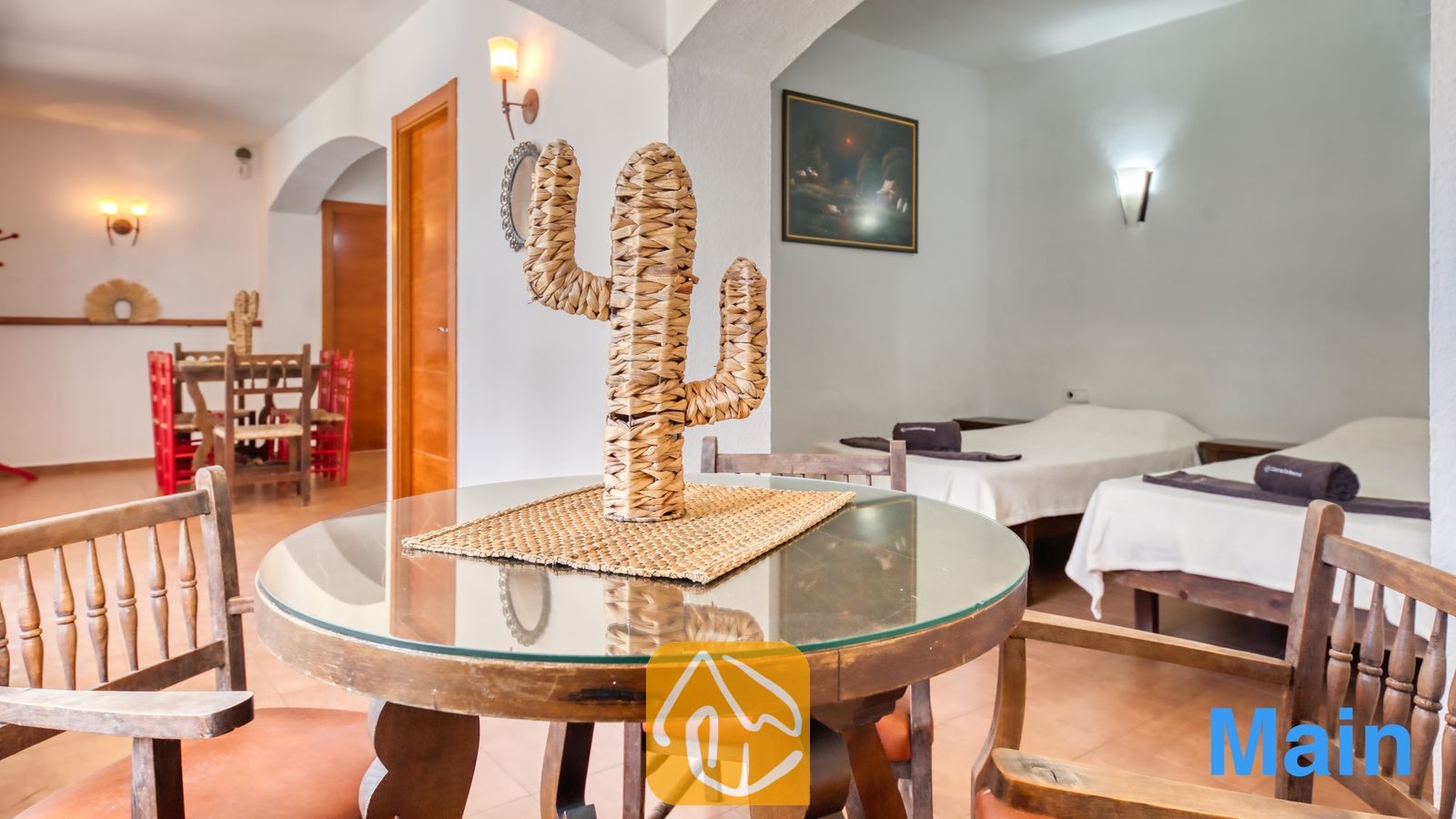 Vakantievilla's Costa Brava Spanje - Villa Pilar - Ronde glazen eettafel met een gevlochten cactusdecoratie, omringd door houten stoelen in Villa Pilar