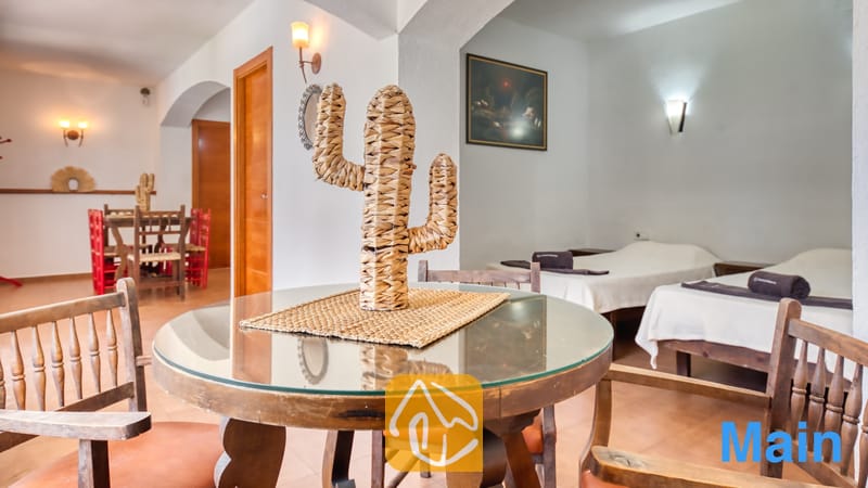 Vakantievilla's Costa Brava Spanje - Villa Pilar - Ronde glazen eettafel met een gevlochten cactusdecoratie, omringd door houten stoelen in Villa Pilar