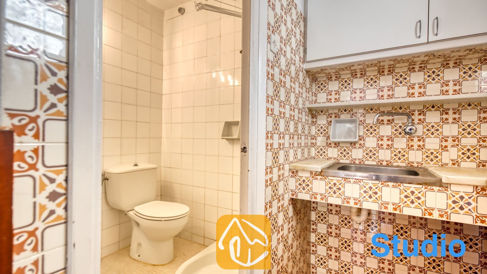 Vakantievilla's Costa Brava Spanje - Villa Pilar - Kleine badkamer en kitchenette met opvallende oranje tegels, witte wandtegels, een wit toilet en een compact wastafelmeubel met witte bovenkasten.