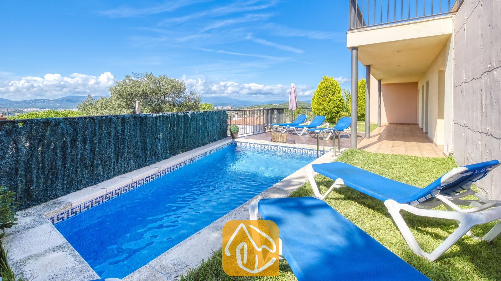 Vakantievilla's Costa Brava Spanje - Villa Mauri - Privézwembad bij Villa Mauri met helderblauw water, een betegelde rand en blauwe ligstoelen op het gras.