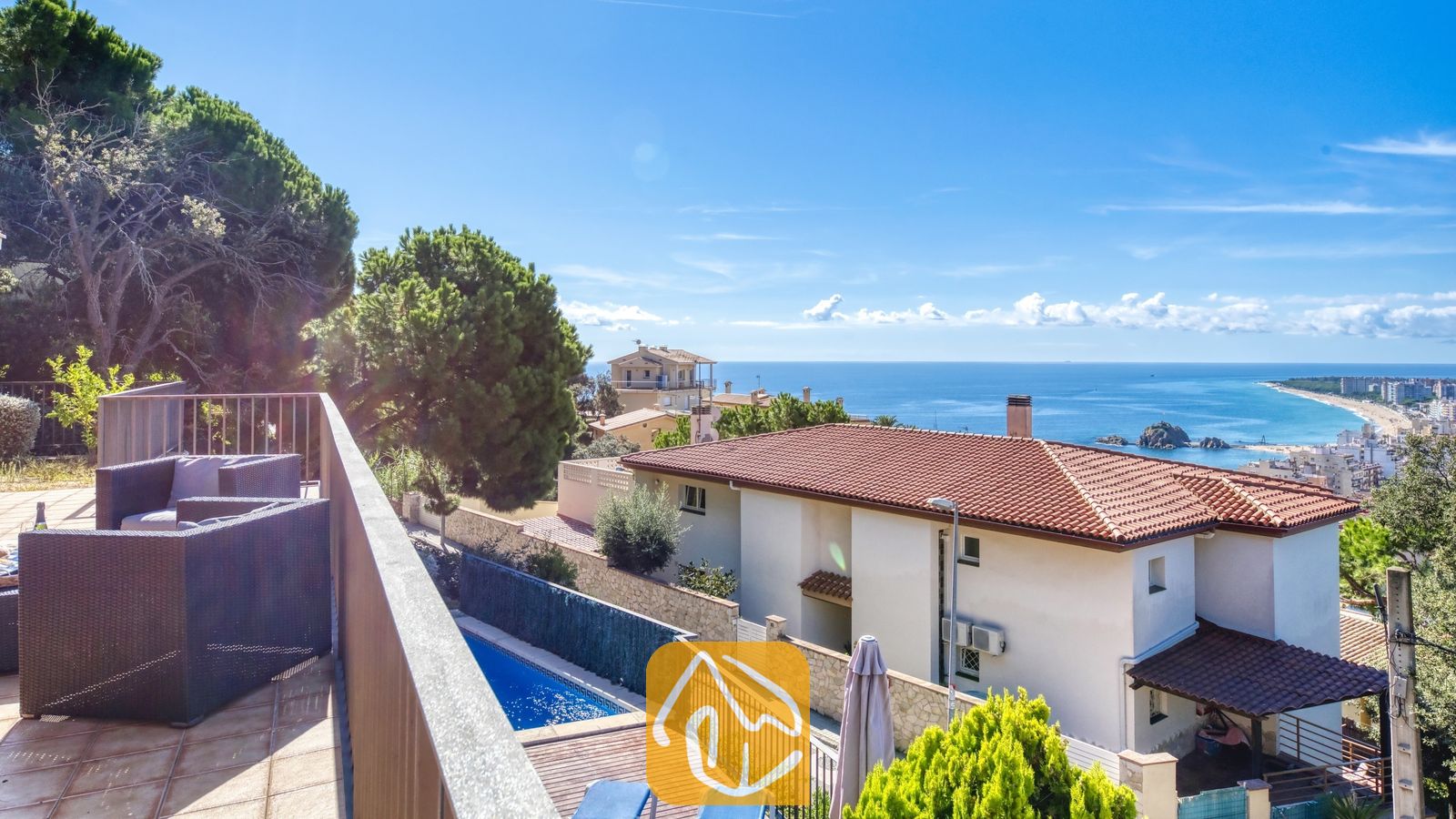 Vakantievilla's Costa Brava Spanje - Villa Mauri - Balkon met donkere wicker fauteuils en uitzicht op Villa Mauri, de omliggende huizen en de blauwe zee.