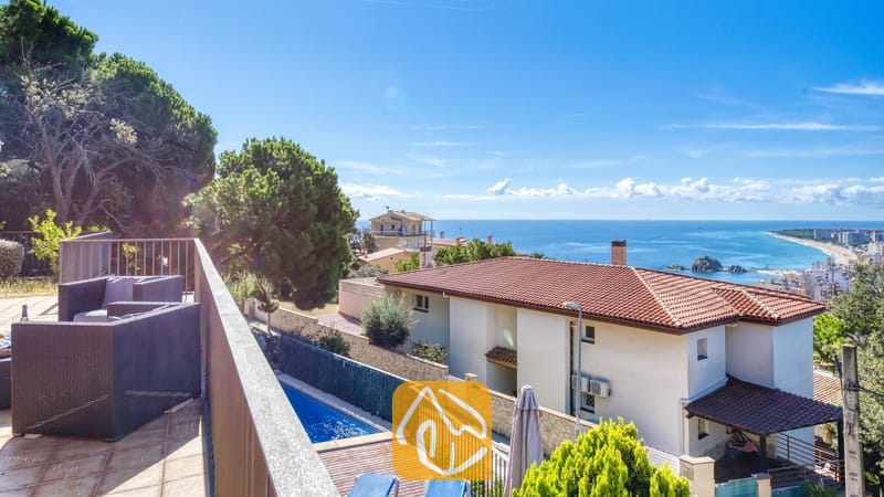 Vakantievilla's Costa Brava Spanje - Villa Mauri - Balkon met donkere wicker fauteuils en uitzicht op Villa Mauri, de omliggende huizen en de blauwe zee.
