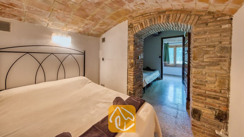 Villas de vacances Costa Brava Countryside Espagne - Villa Can Bernardi - Chambre avec plafond voûté en briques et porte en arc de pierre menant à une pièce attenante à la Villa Can Bernardi
