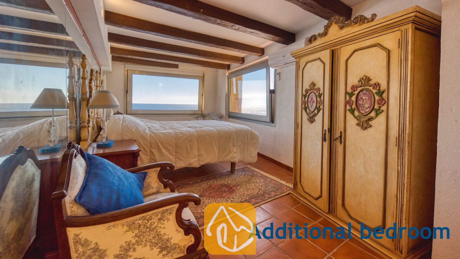 Vakantievilla's Costa Brava Spanje - Villa Infinity - Slaapkamer met houten plafondbalken, een grote kledingkast, tegelvloer en twee ramen met uitzicht op zee.