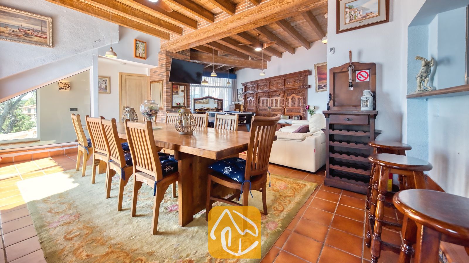 Vakantievilla's Costa Brava Spanje - Villa Infinity - Ruime eethoek in Villa Infinity, voorzien van een grote houten tafel met bijpassende stoelen, authentieke houten balken aan het plafond en een terracotta tegelvloer.