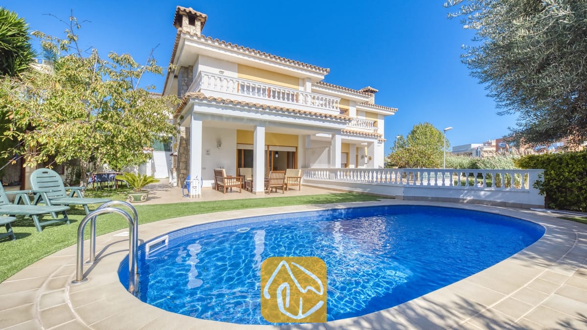 Vakantievilla's Costa Brava Spanje - Villa Baileys - Privézwembad met helderblauw water en metalen leuningen voor de buitenkant van de twee verdiepingen tellende Villa Baileys, voorzien van witte zuilen, balkons en een pannendak tegen een heldere hemel.