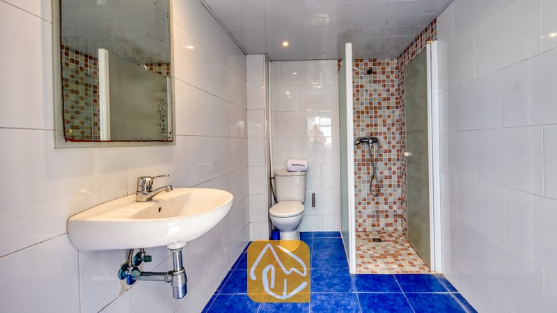 Villas de vacances Costa Brava Espagne - Villa Sandy Beach - Salle de bain agrémentée d'un carrelage au sol bleu, d'un lavabo blanc suspendu et d'une douche à l'italienne ornée d'une mosaïque aux tons variés.