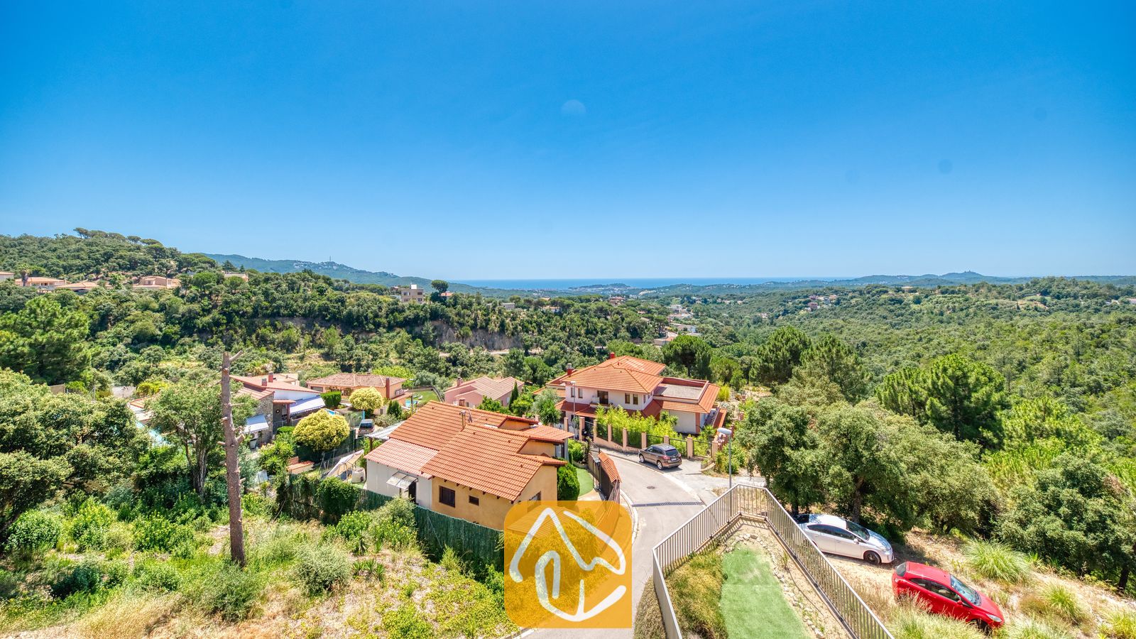 Vakantievilla's Costa Brava Spanje - Villa Sandy Beach - Geniet van een prachtig uitzicht op de villa's met hun karakteristieke rode daken, omringd door weelderige groene bossen en heuvels, met de azuurblauwe zee aan de horizon bij Villa Sandy Beach.