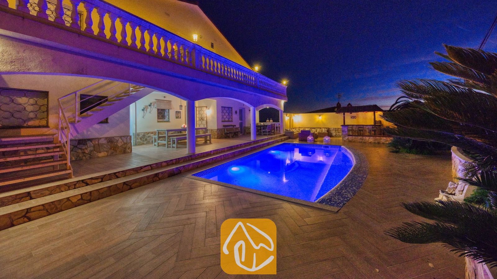Vakantievilla's Costa Brava Spanje - Villa Madonna - Verlicht zwembad en terras van Villa Madonna bij nacht, met buitenverlichting, een overdekte veranda en zitgelegenheid buiten.