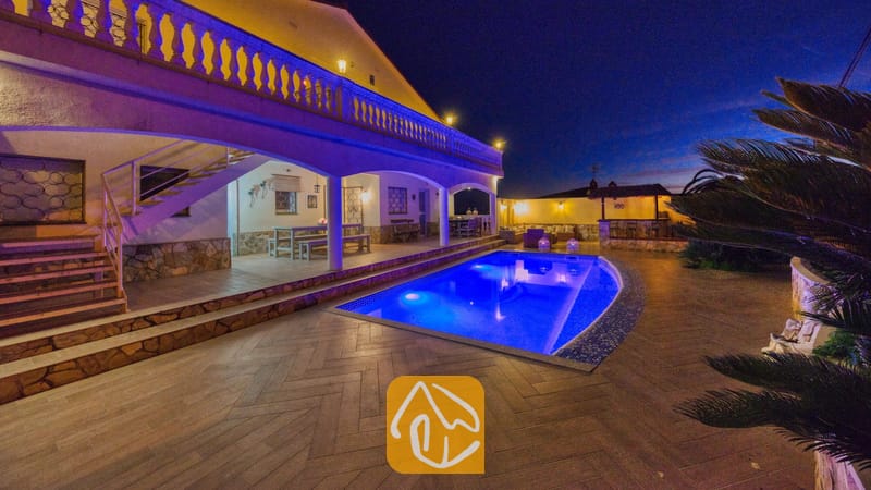 Vakantievilla's Costa Brava Spanje - Villa Madonna - Verlicht zwembad en terras van Villa Madonna bij nacht, met buitenverlichting, een overdekte veranda en zitgelegenheid buiten.
