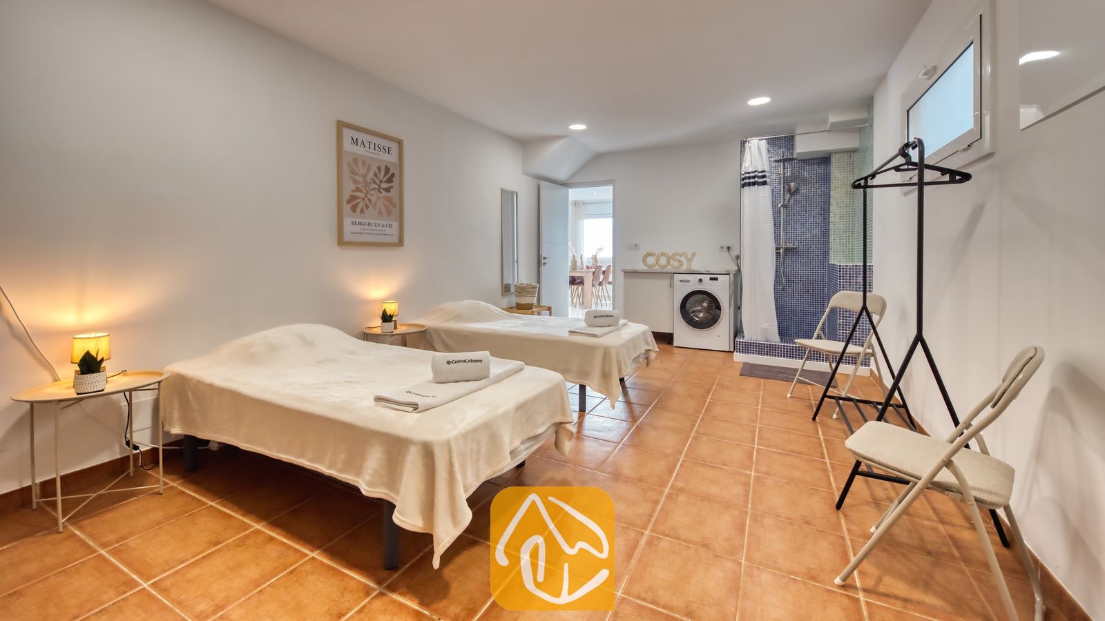 Vakantievilla's Costa Brava Spanje - Villa La Luna - Gasten slaapkamer met twee eenpersoonsbedden, terracotta tegelvloer, nachtkastlampjes en een en-suite doucheruimte met blauwe mozaïektegels.