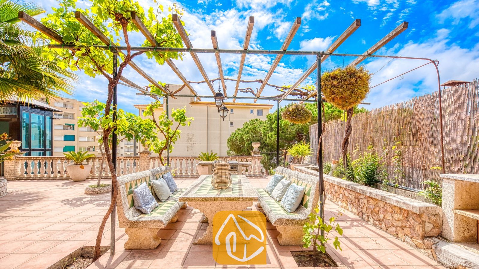 Vakantievilla's Costa Brava Spanje - Villa Dolce Vita - Buiten eettafel van steen onder een houten pergola met klimplanten op het dakterras van Villa Dolce Vita.
