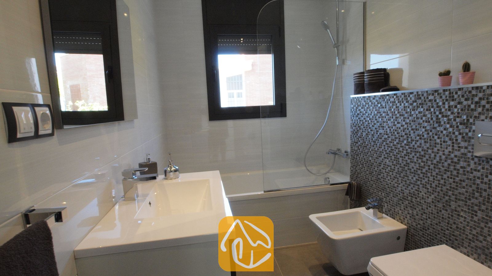 Vakantievilla's Costa Brava Spanje - Villa SummerDream - Moderne badkamer met een wit wastafelmeubel, een ligbad met een glazen scherm en wandaccenten van grijze mozaïektegels.