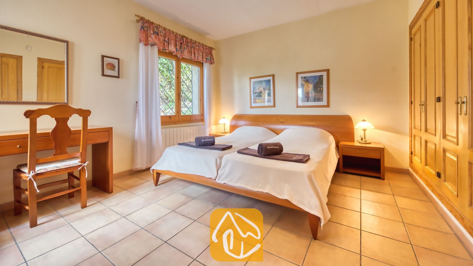 Vakantievilla's Costa Brava Spanje - Villa Cleo - Slaapkamer met twee eenpersoonsbedden, een houten hoofdbord, nachtkastlampjes, tegelvloeren en een schrijfdesk bij Villa Cleo.