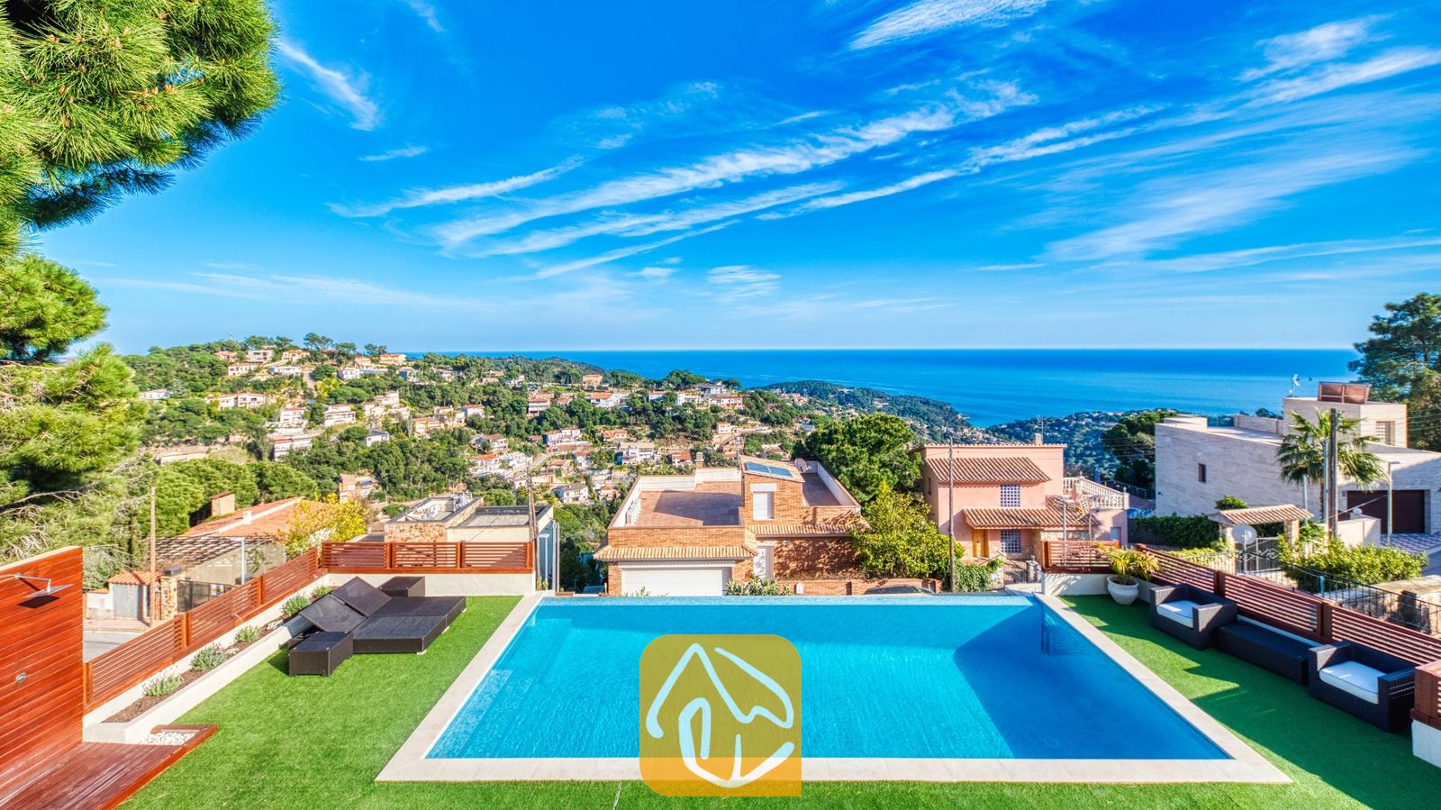 Vakantievilla's Costa Brava Spanje - Villa Chanel - Privézwembad bij Villa Chanel met kunstgras, zwarte loungeset en een panoramisch uitzicht over de Middellandse Zee en het kustplaatsje.