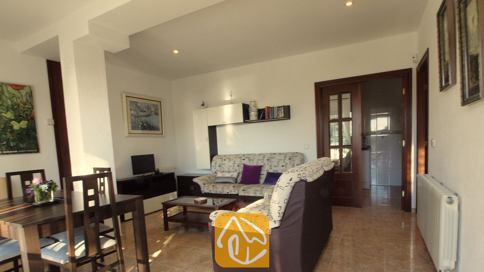 Vakantievilla's Costa Brava Spanje - Villa Noa - Woon- en eetkamer in Villa Noa met gestoffeerde banken, een houten eettafel en tegelvloeren.