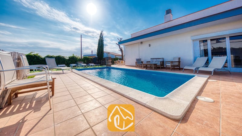 Vakantievilla's Costa Brava Spanje - Villa Yara - Buitenzwembad met betegeld terras en ligstoelen bij Villa Yara in Spanje.