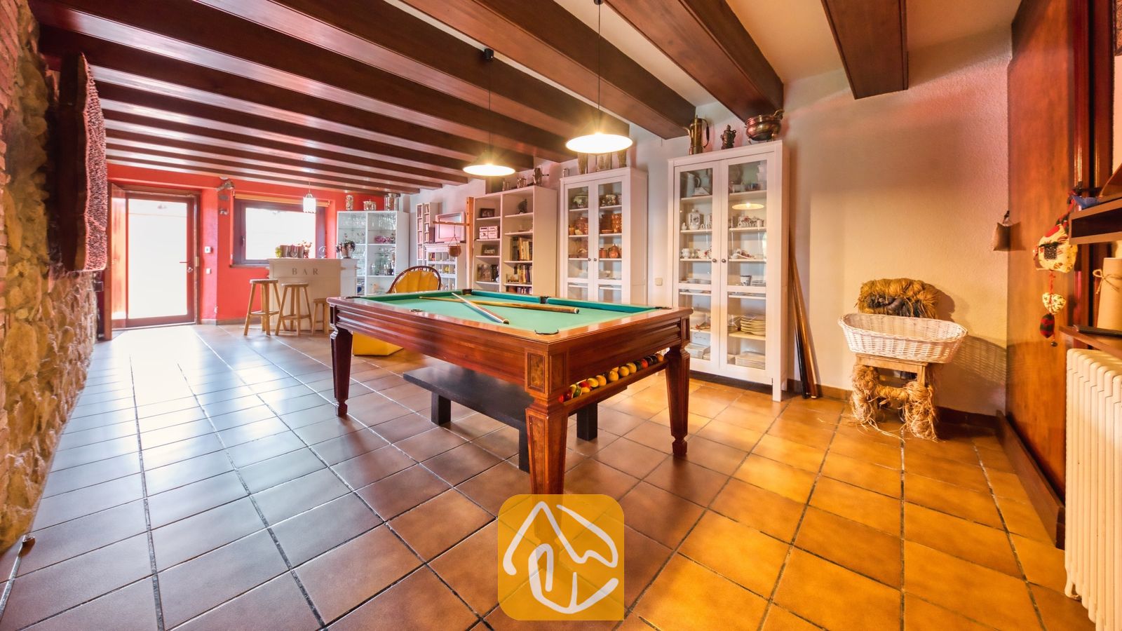 Vakantievilla's Costa Brava Spanje - Villa Paradise - Spelkamer bij Villa Paradise met een houten biljarttafel met een groen viltlokaal onder zichtbare donkere plafondbalken en terracotta vloertegels.