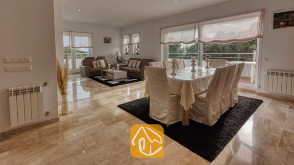 Vakantievilla's Costa Brava Spanje - Villa Madison - Ruime woon- en eetkamer in Villa Madison, voorzien van gepolijste marmeren vloeren, een overdekte eettafel en bruine leren banken.