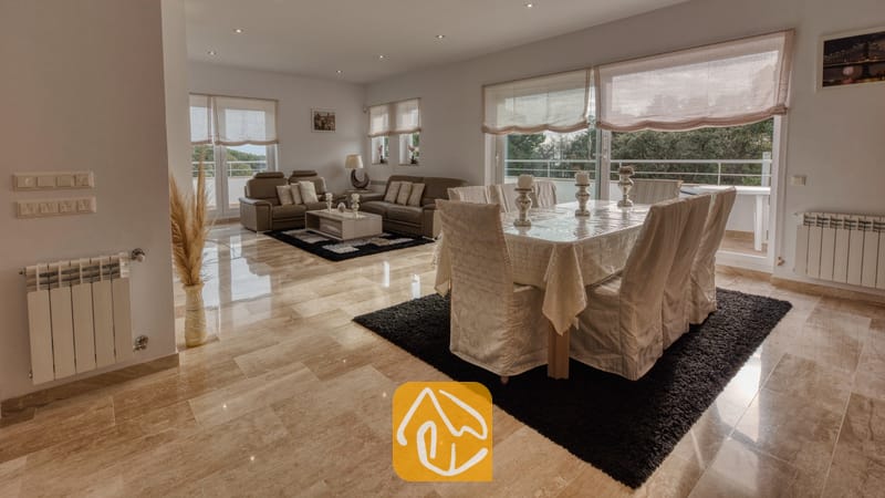 Vakantievilla's Costa Brava Spanje - Villa Madison - Ruime woon- en eetkamer in Villa Madison, voorzien van gepolijste marmeren vloeren, een overdekte eettafel en bruine leren banken.