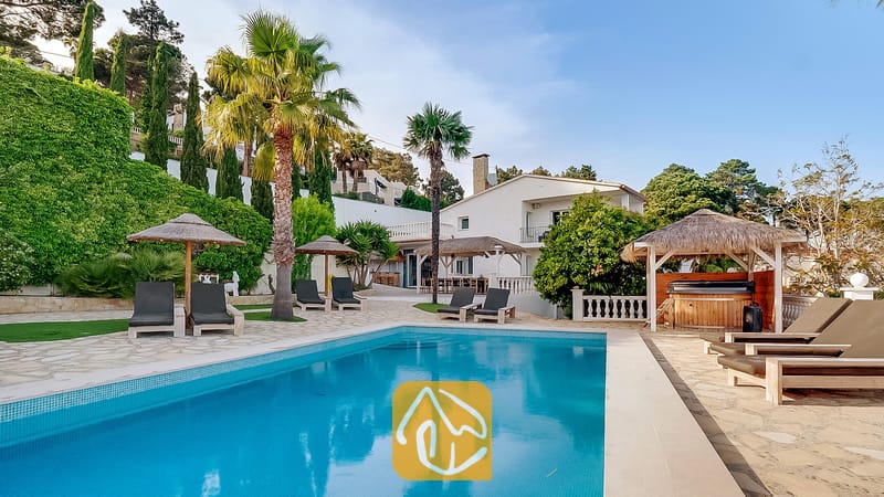 Vakantievilla's Costa Brava Spanje - Villa Tropicana - Het buitenzwembad van Villa Tropicana, voorzien van ligstoelen, palmbomen, rieten parasols en een houten prieel waarin zich een hottub bevindt.