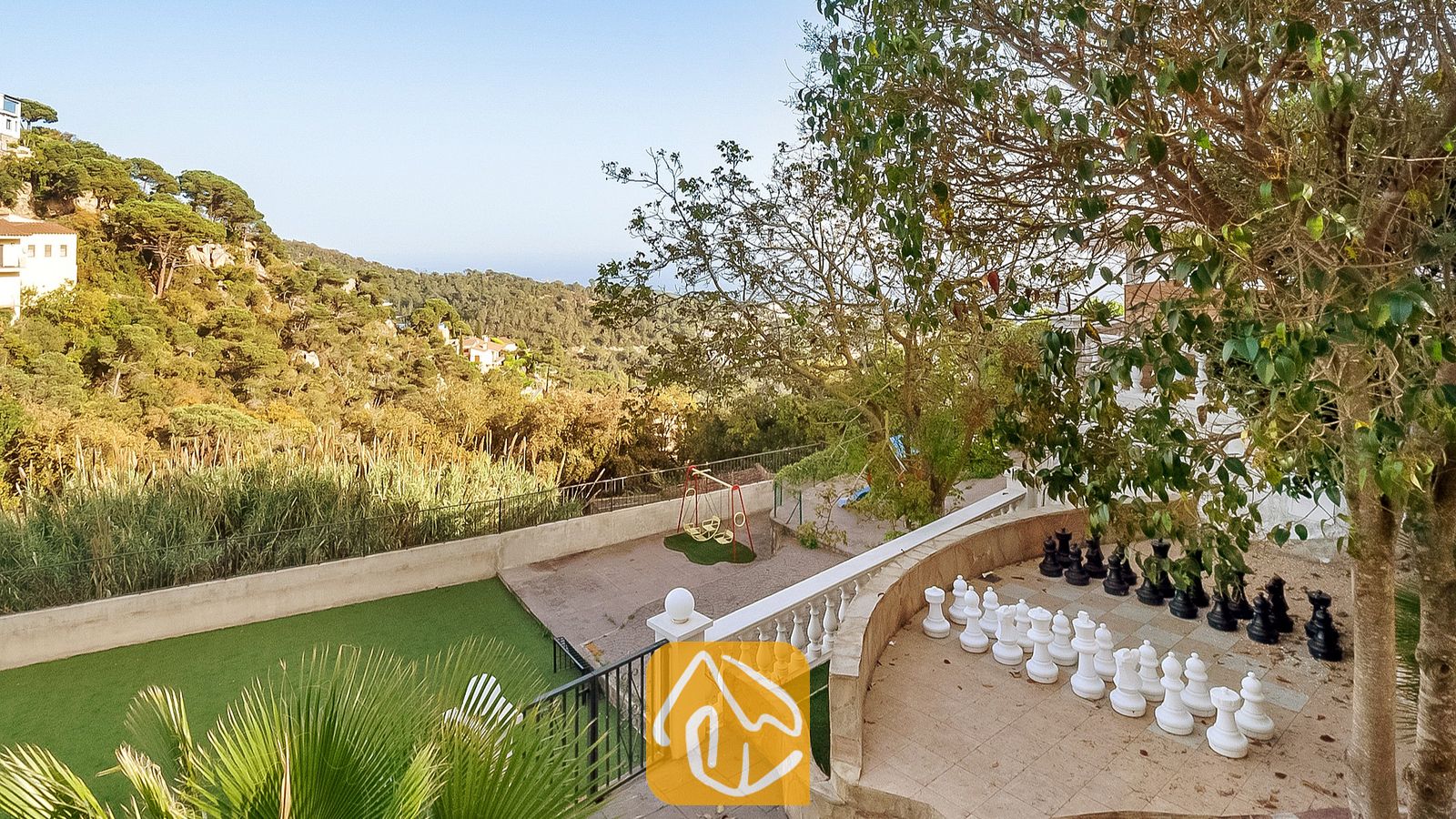 Vakantievilla's Costa Brava Spanje - Villa Tropicana - Groot buiten-schaakspel op een stenen terras bij Villa Tropicana met uitzicht op groene heuvels en bomen