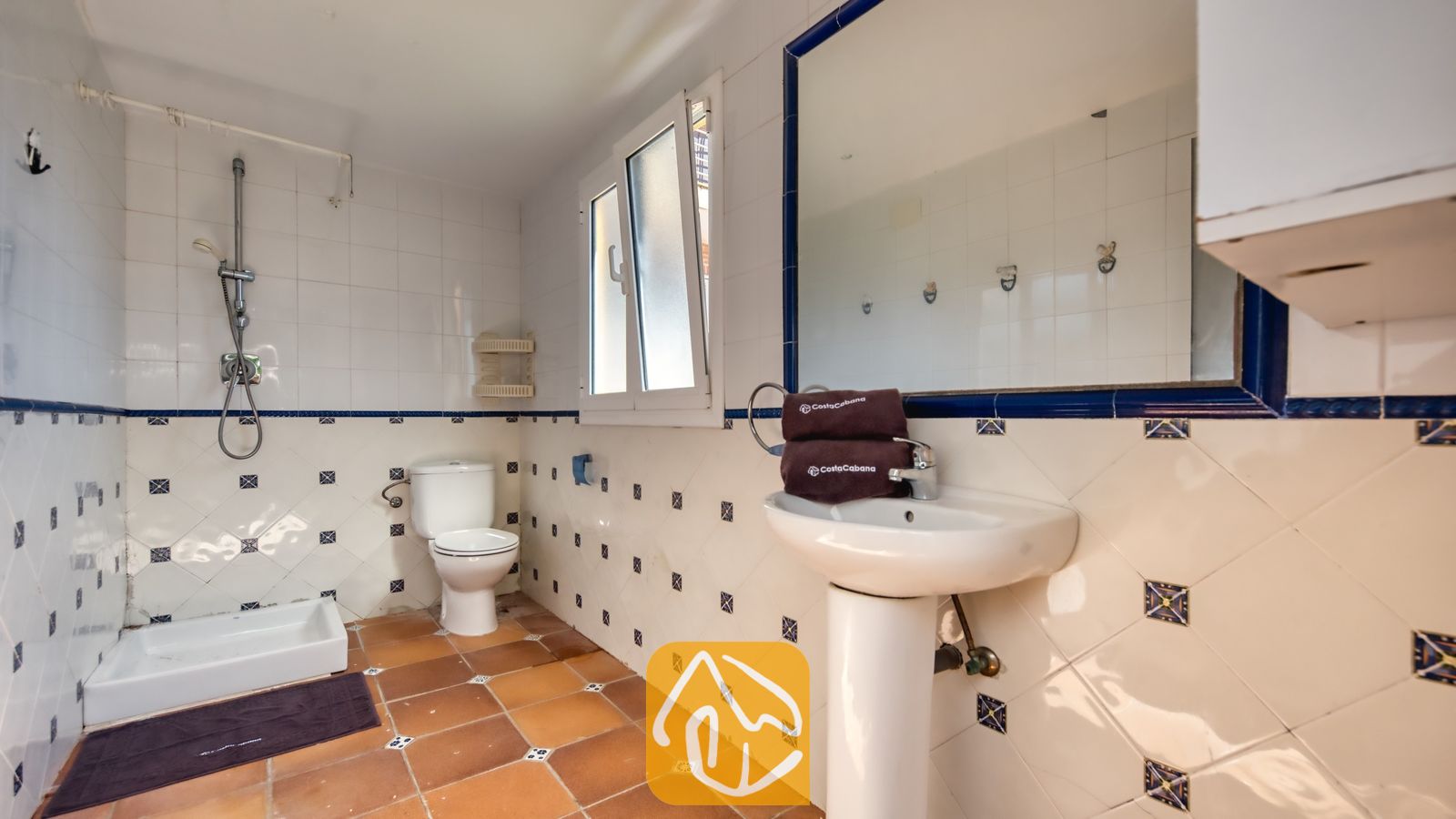 Vakantievilla's Costa Brava Spanje - Villa Beyonce - Badkamer met een witte zuilwastafel, betegelde douche en bruine vloertegels