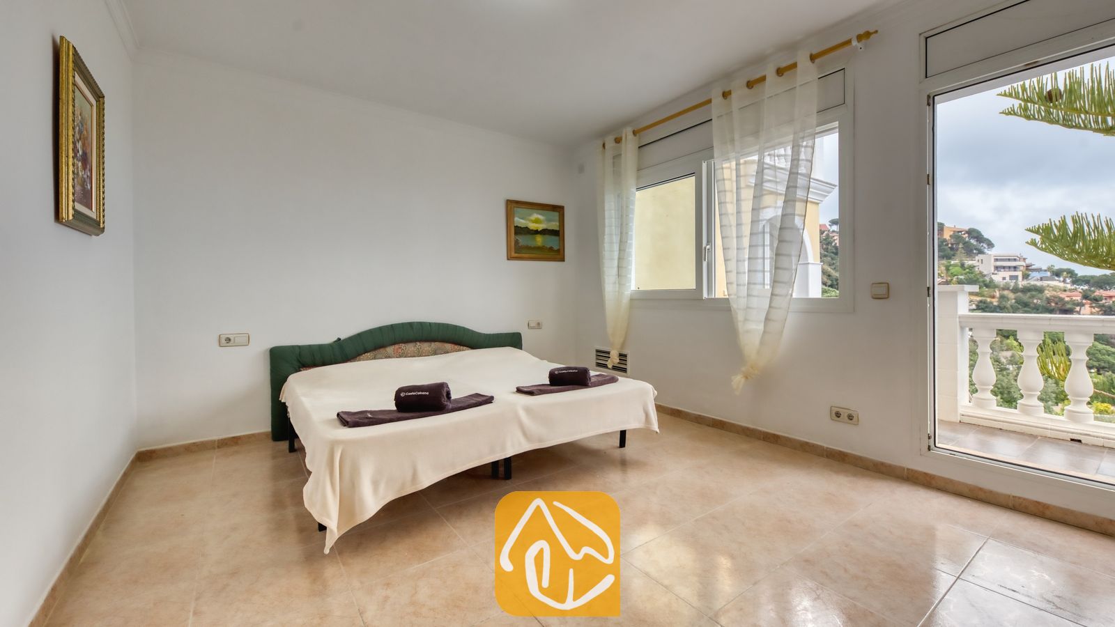 Vakantievilla's Costa Brava Spanje - Villa Sunrise - Slaapkamer met een tweepersoonsbed, tegelvloeren, witte muren en een balkondeur met uitzicht naar buiten