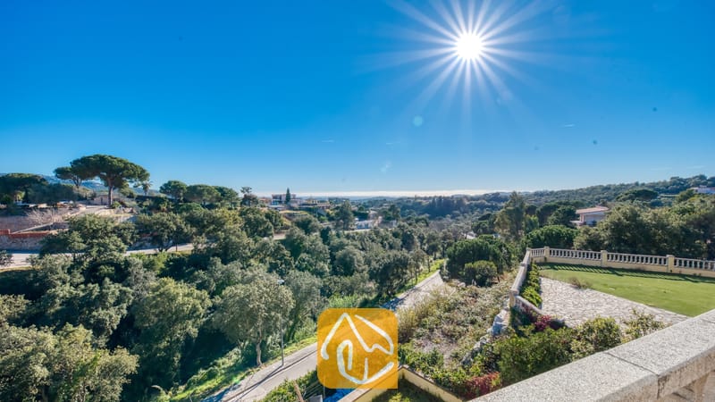 Villas de vacances Costa Brava Espagne - Villa Holiday - Vue depuis le balcon de la Villa Holiday, surplombant des forêts verdoyantes, des routes sinueuses et un ciel radieux et ensoleillé aux rayons éclatants.