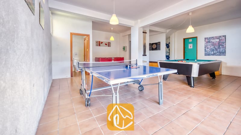 Villas de vacances Costa Brava Espagne - Villa Holiday - Salle de jeux comprenant une table de ping-pong bleue au premier plan, un billard vert sur la droite et un baby-foot rouge en arrière-plan.