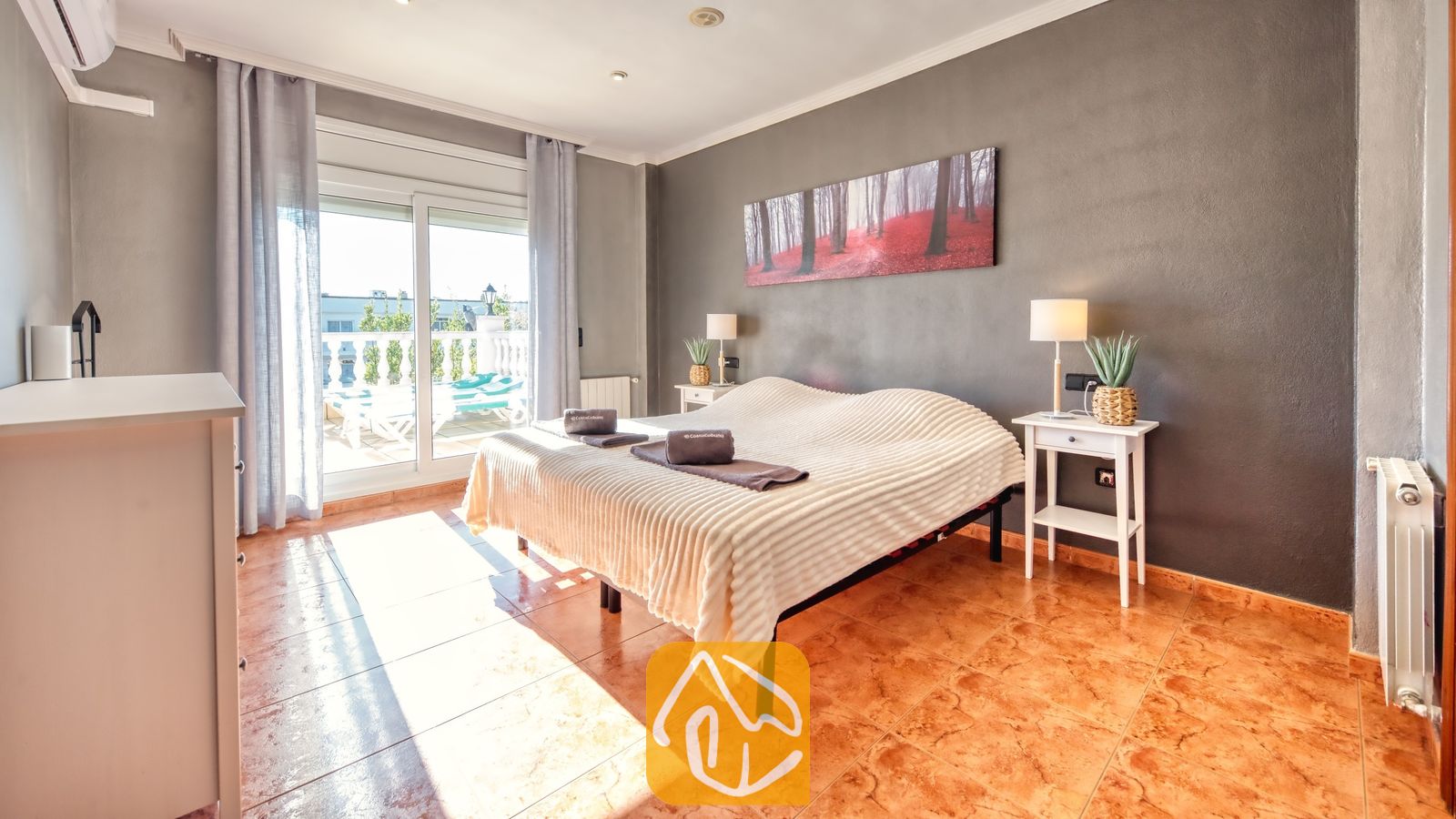 Vakantievilla's Costa Brava Spanje - Villa Summertime - Slaapkamer met een tweepersoonsbed, witte nachtkastjes met lampen, donkergrijze muren, tegelvloer en een schuifpui die toegang biedt tot een balkon.