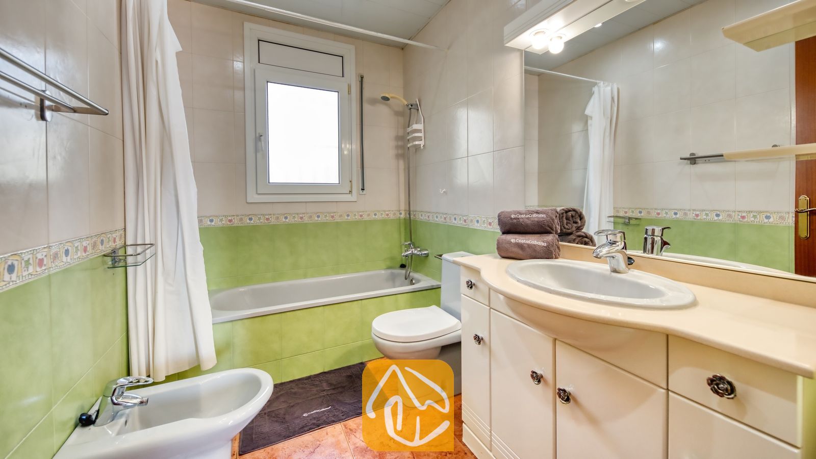 Vakantievilla's Costa Brava Spanje - Villa Summertime - Badkamer voorzien van een ligbad, bidet, wit toilet en een wastafelmeubel onder een grote verlichte spiegel.