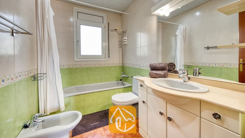 Vakantievilla's Costa Brava Spanje - Villa Summertime - Badkamer voorzien van een ligbad, bidet, wit toilet en een wastafelmeubel onder een grote verlichte spiegel.