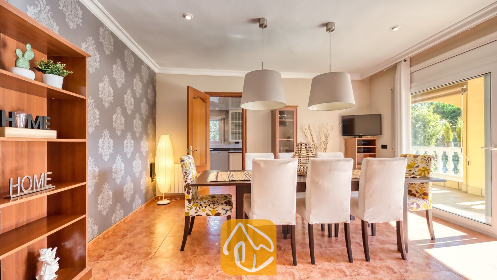 Vakantievilla's Costa Brava Spanje - Villa Summertime - Eetkamer met een donkerhouten tafel, witte gestoffeerde stoelen, stoelen met een motief aan het hoofdeneinde en twee grote hanglampen bij Villa Summertime.