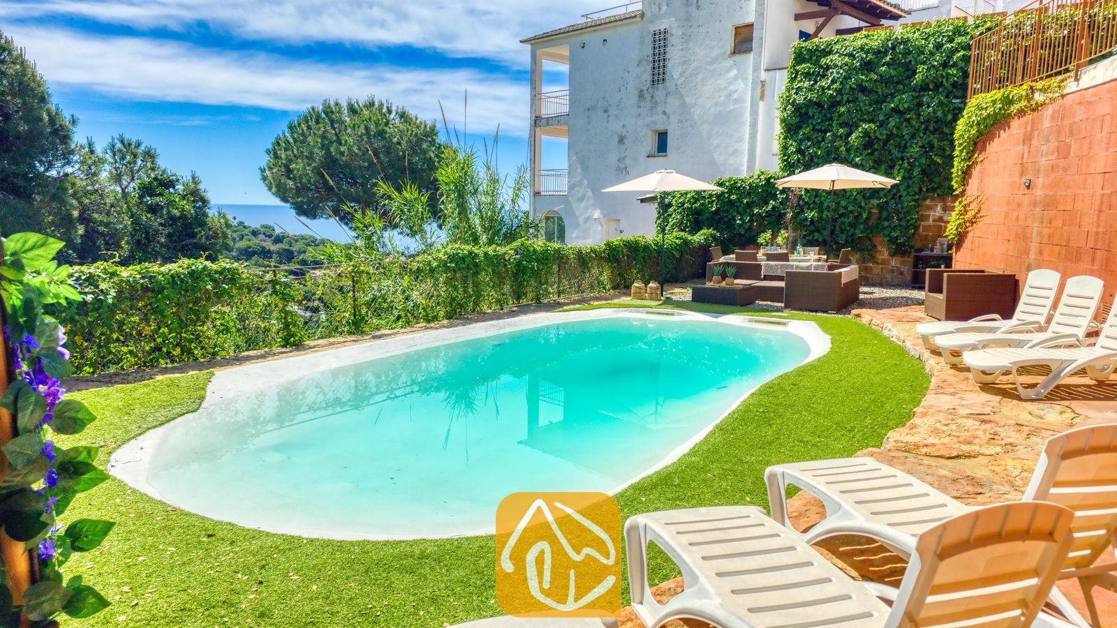 Vakantievilla's Costa Brava Spanje - Villa Sunny Beach - Privézwembad met ligstoelen en zitgelegenheid buiten bij Villa Sunny Beach in Spanje, voorzien van een groen gazon, witte zonneschermen en uitzicht op zee op de achtergrond.