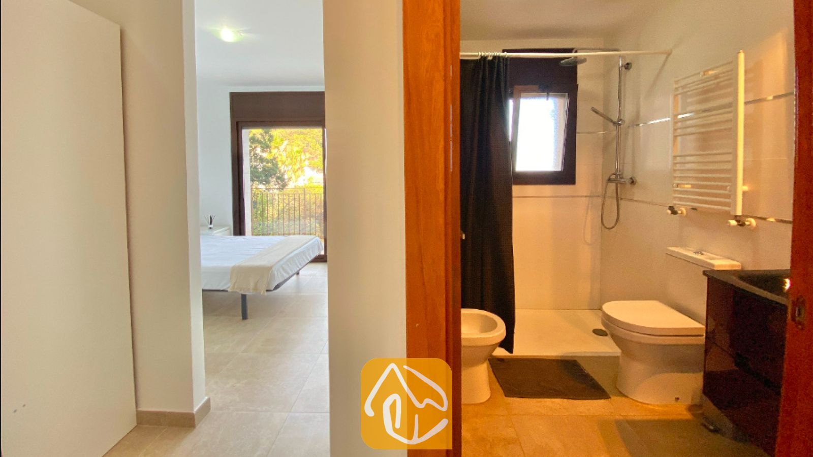 Vakantievilla's Costa Brava Spanje - Villa Sunny Beach - Badkamer met douche en toilet gezien door een deuropening, met een slaapkamer zichtbaar in de gang