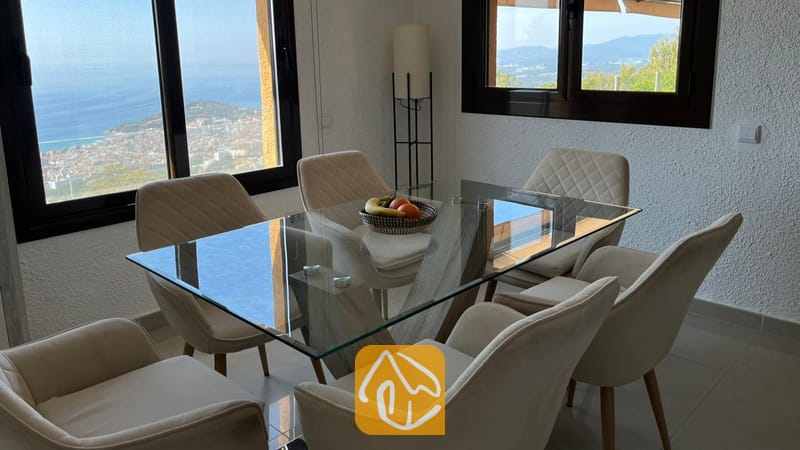 Vakantievilla's Costa Brava Spanje - Villa VistaMar - Eethoek in Villa VistaMar met een glazen tafel, zes gestoffeerde stoelen en grote ramen met uitzicht op de kust.