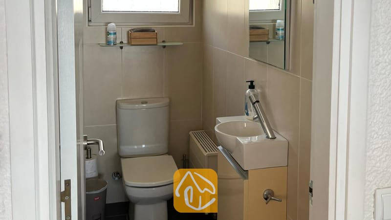 Villas de vacances Costa Brava Espagne - Villa VistaMar - Petite salle de bains carrelée comprenant des toilettes blanches, un lavabo compact avec un robinet moderne et un miroir mural.
