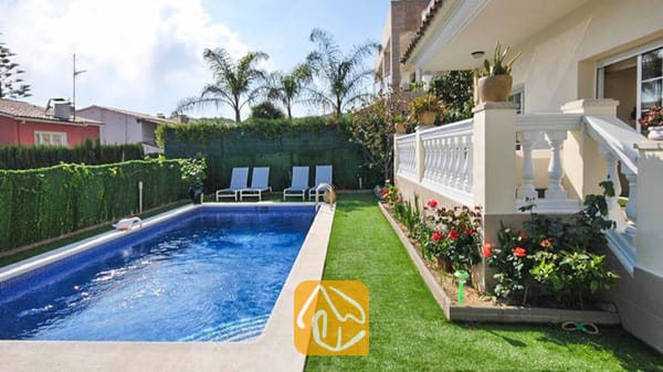 Vakantievilla's Costa Brava Spanje - Villa Mercedes Fenals - Privézwembad met blauwe betegeling bij Villa Mercedes Fenals, omringd door kunstgras, ligstoelen en een terras met een witte balustrade.